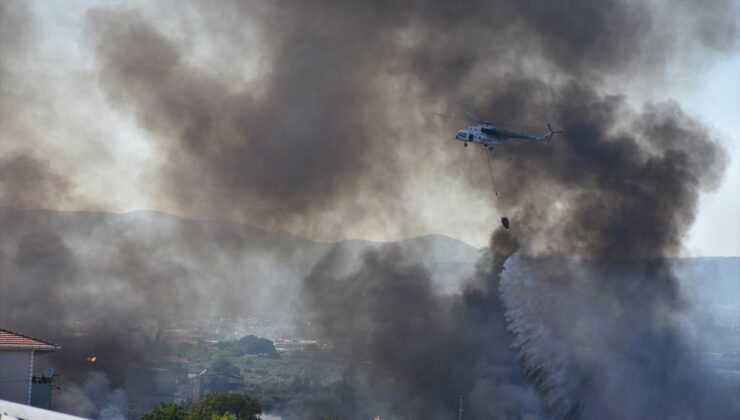 İzmir'de palet atölyesinde çıkıp otluk alana sıçrayan yangına ekiplerce müdahale ediliyor